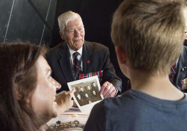 A young boy and a woman meet a veteran in the meet the veterans event at IWMN