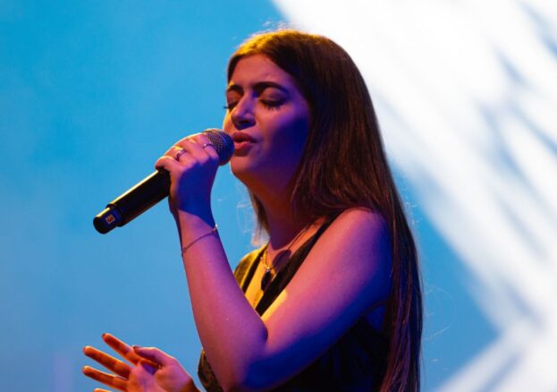 Photo of female artist singing in microphone