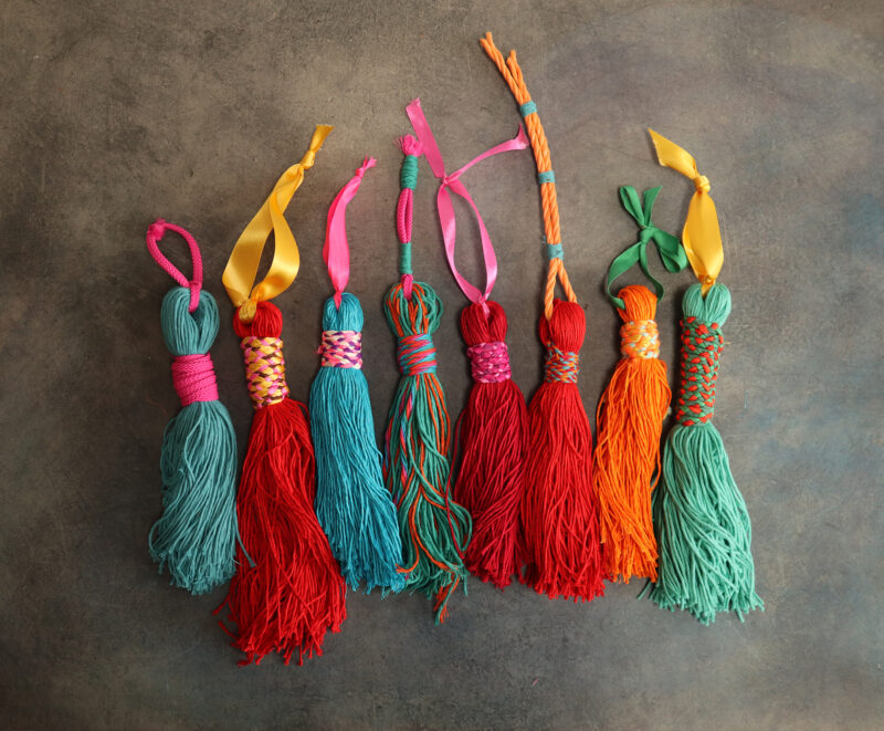 Tassels in turquoise, red and orange all in a row before they have been added to the sculpture