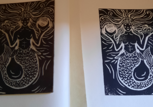 a print of a mermaid in black in and the lino from which the print was taken.