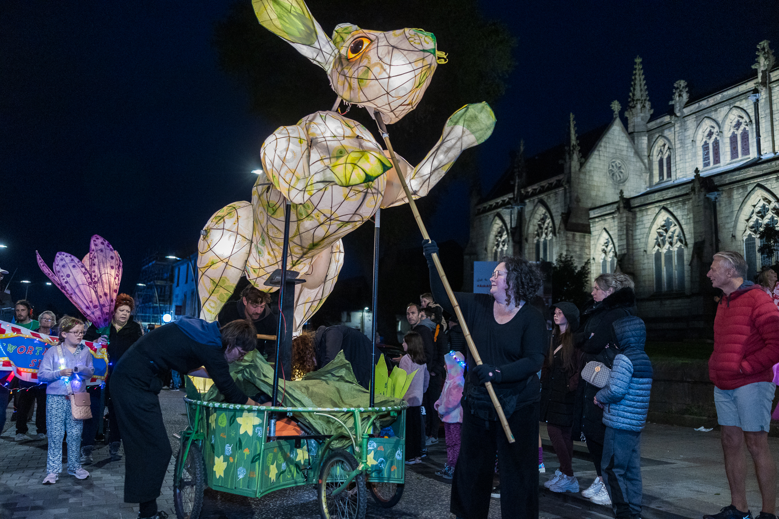 A large rabbit puppet illuminated in a procession at Encounter Festival.