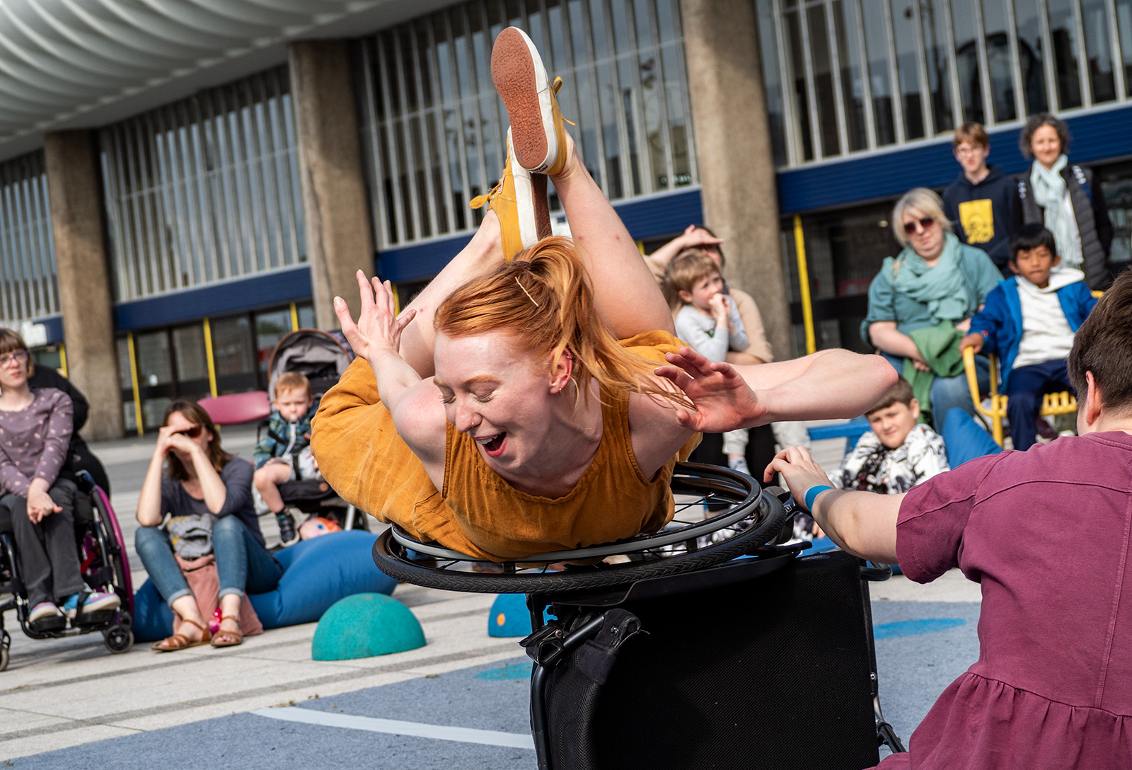 A performer balances on the wheel of a wheelchair at Encounter Festival.