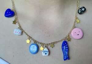 A gold necklace with colourful clay charms