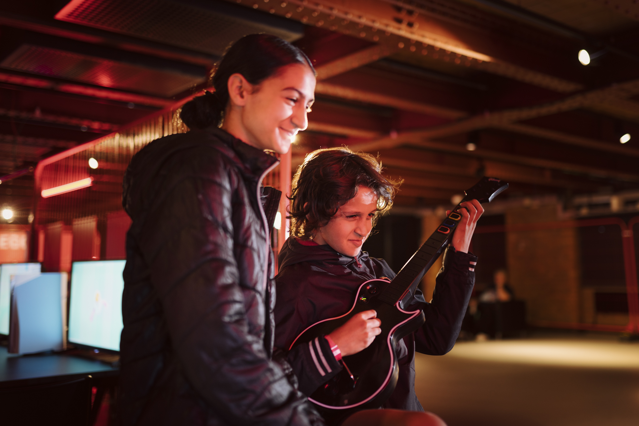 Boy and girl playing Guitar Hero in Power Up.