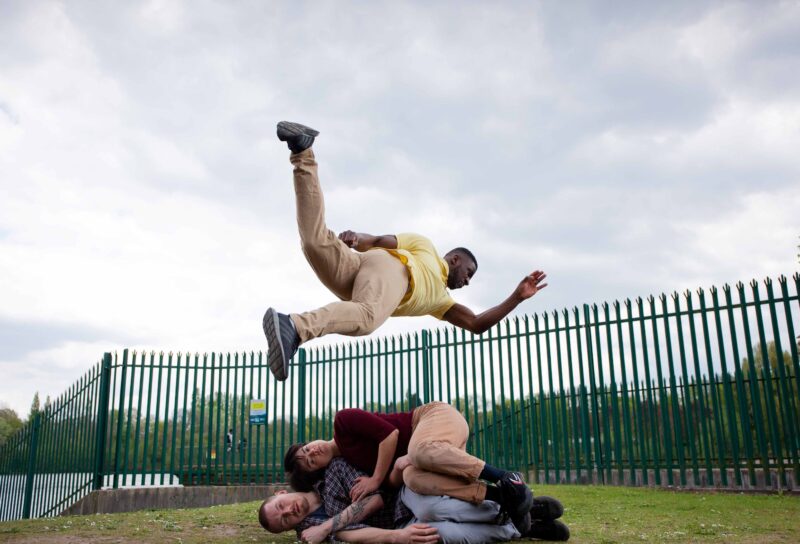 dancer suspended in air above two other dancers