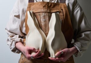 Person holding two white ceramics