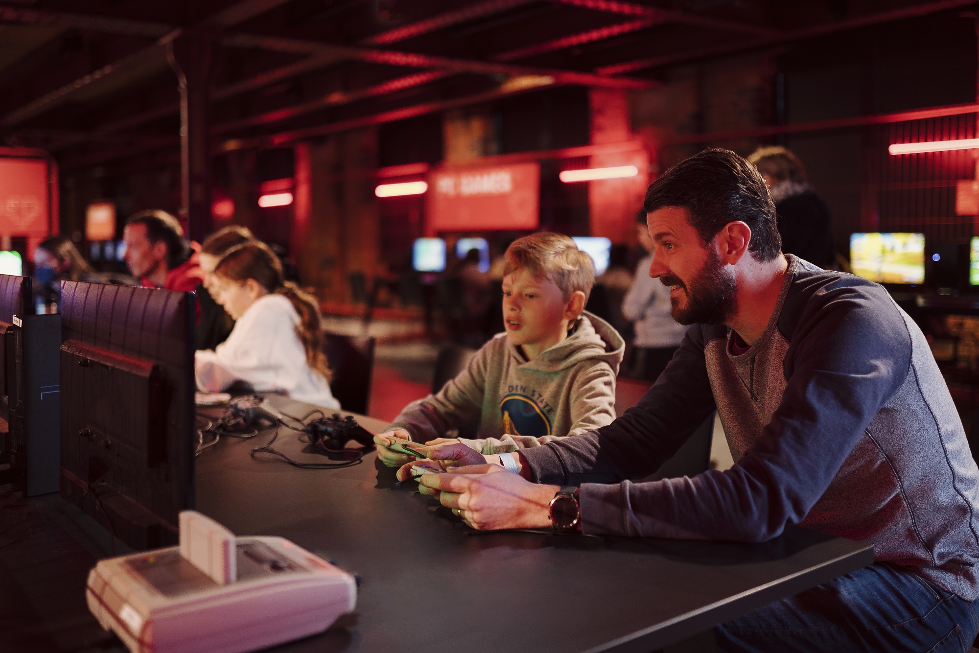 Father and son playing on a retro console in Power Up