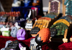 image shows an alternative stall, filled with unusual items and decorations like fairy doors and dragons eggs.