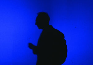 Blue Now at Aviva Studios: Silhoutte of a figure stood infront of a blue light.