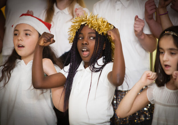 Happy children wearing Christmas hats and crowns made of tinsel