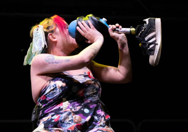 Jackie Hagan stood on stage drinking from her prosthetic leg