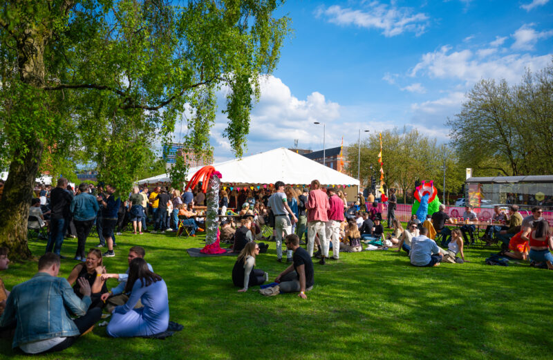 People stood around on a sunny day in front of a marquee