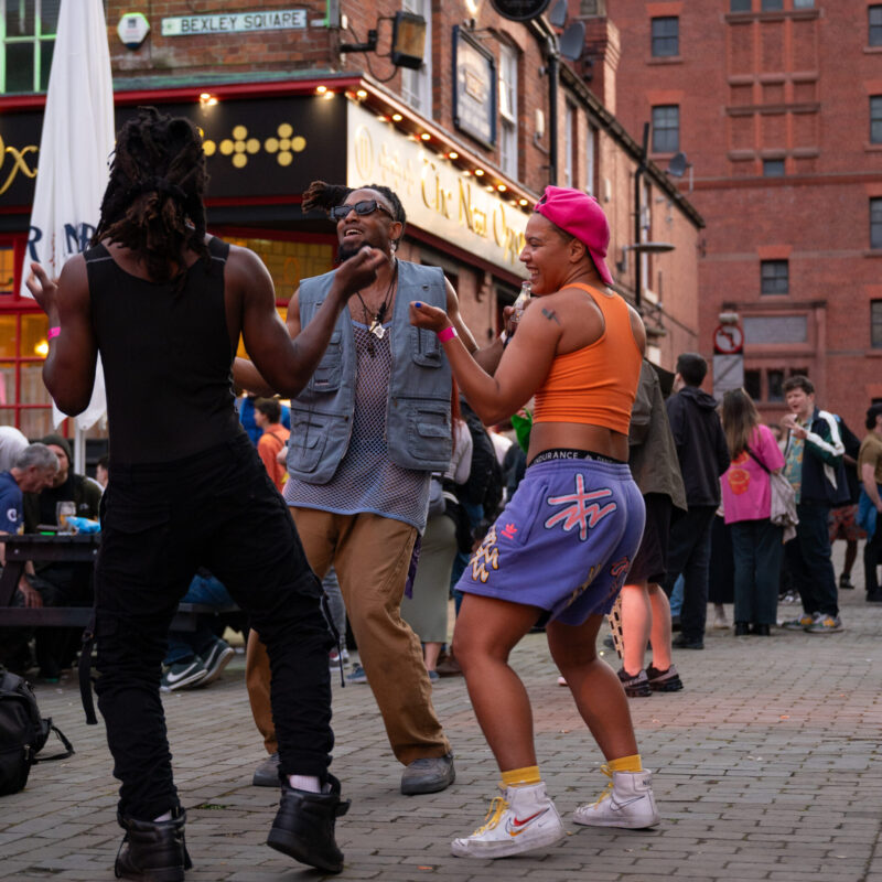 Three people dancing in Bexley Square