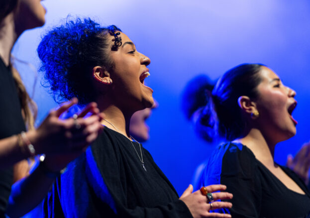 Singers on stage with blue lighting