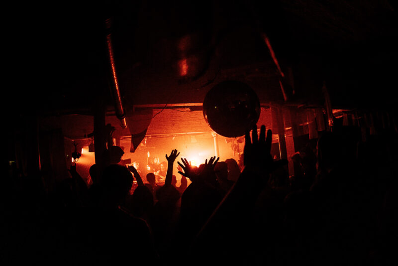 Hands in the air in a dark venue